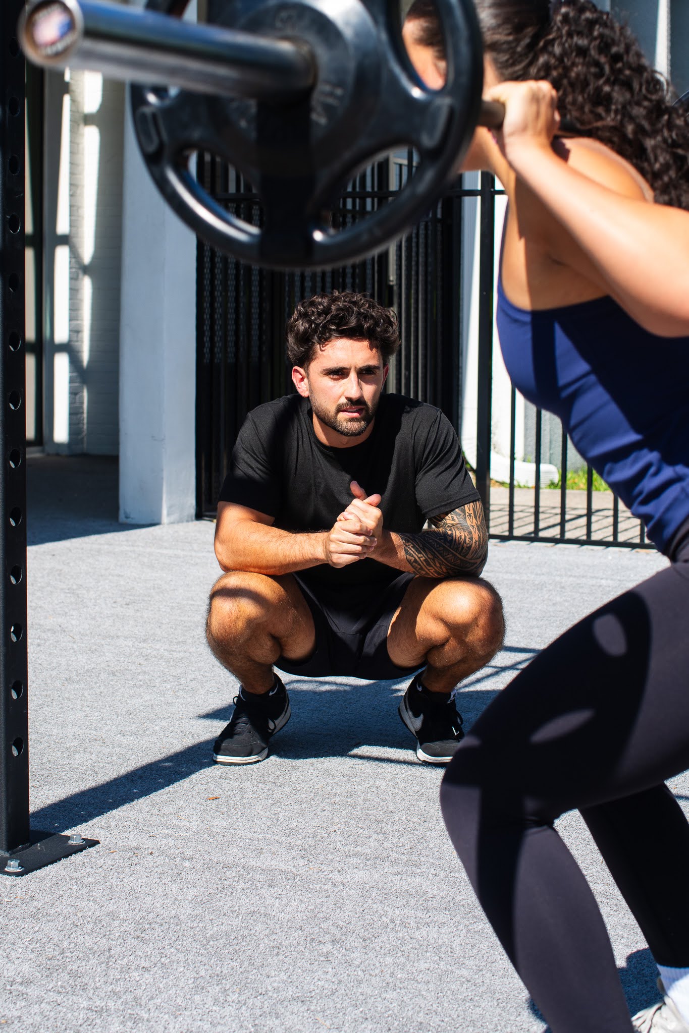 Dain coaching a client through a deep squat
